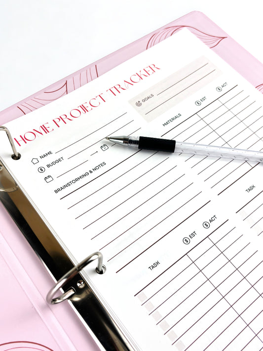 Home project tracker with a pen on a pink surface