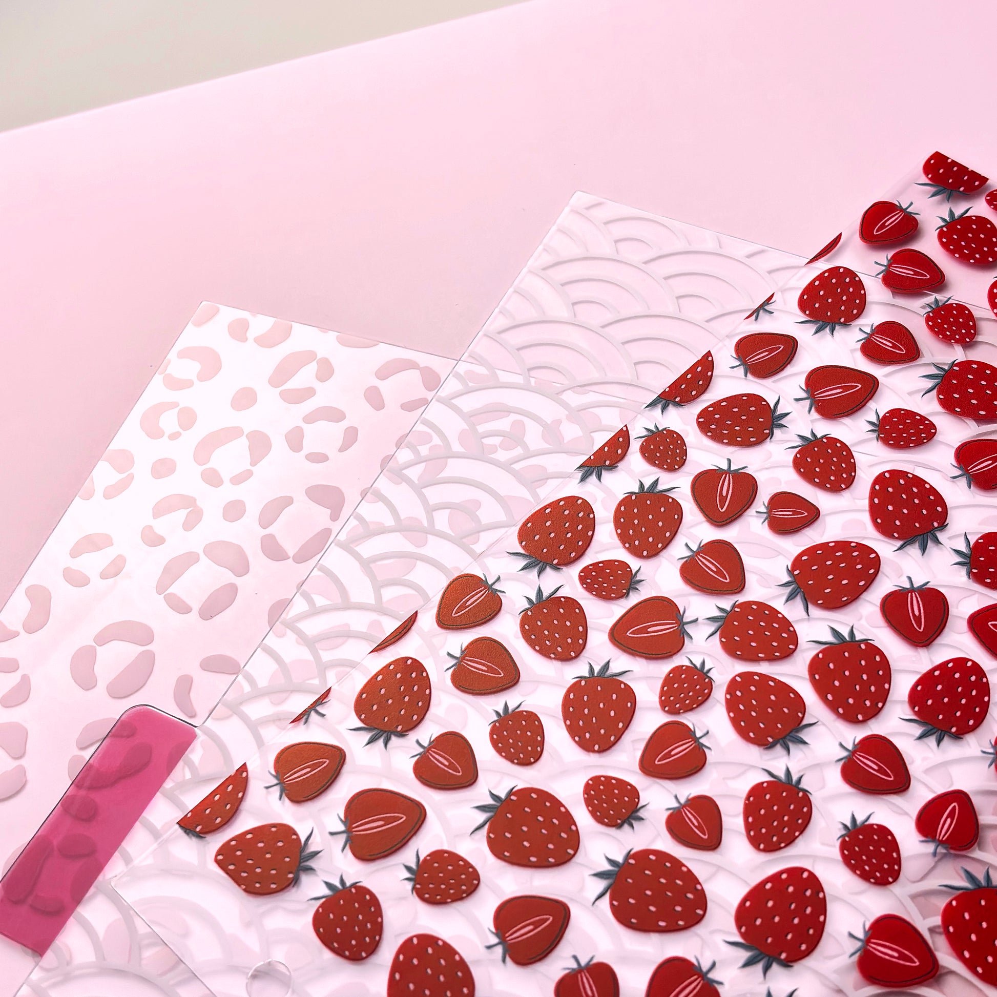 Sheet of strawberry-patterned dividers on a pink background