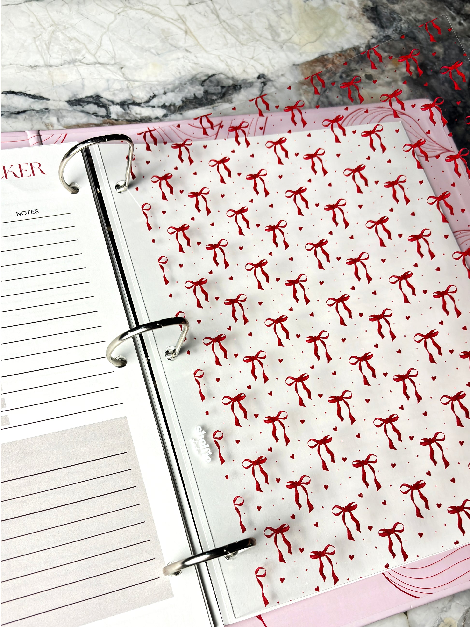 Planner with red bow pattern on a marble surface