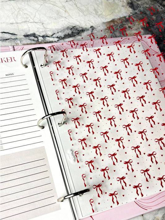 Planner with red bow pattern on a marble surface